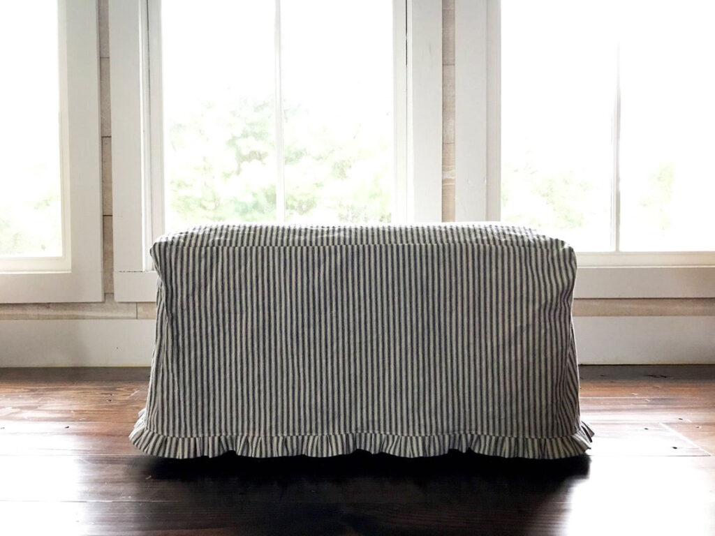 Ticking stripe ottoman slipcover with little ruffle.