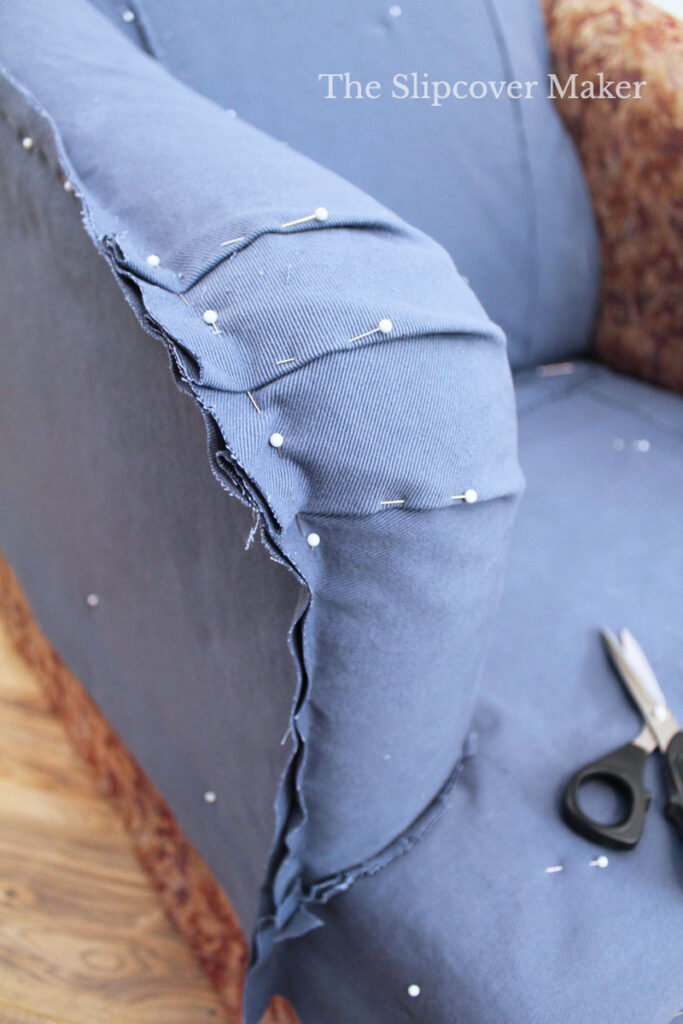 Blue denim slipcover with pinned seams.