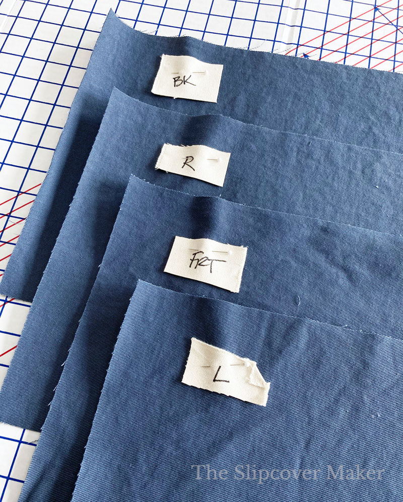 Blue denim slipcover skirt panels cut and stacked.