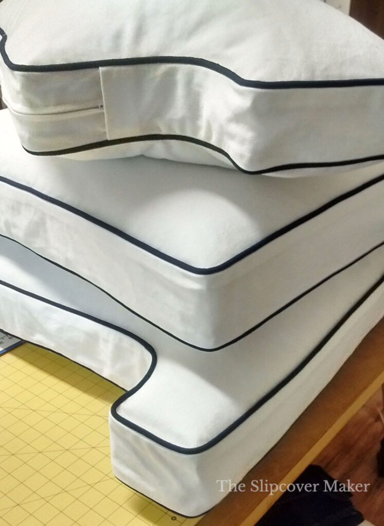 Stack of white box cushions on table.