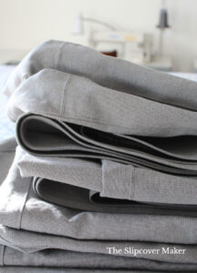Folded and stacked grey canvas cushion covers.