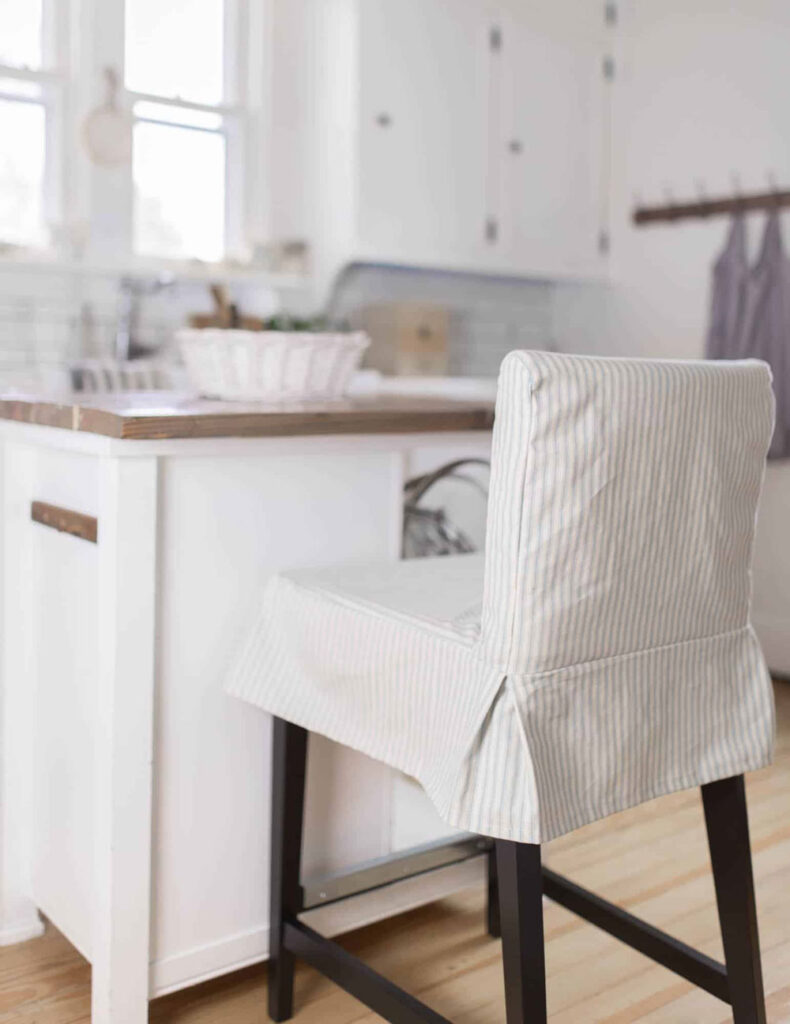 Striped slipcover on kitchen barstool chair.