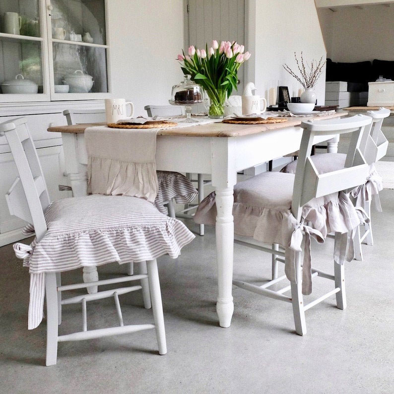 Dining chairs with ruffled seat covers.