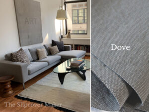 Modern sofa with grey slipcover in apartment.