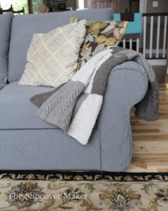 Grey canvas chair with pillows and wool blanket.