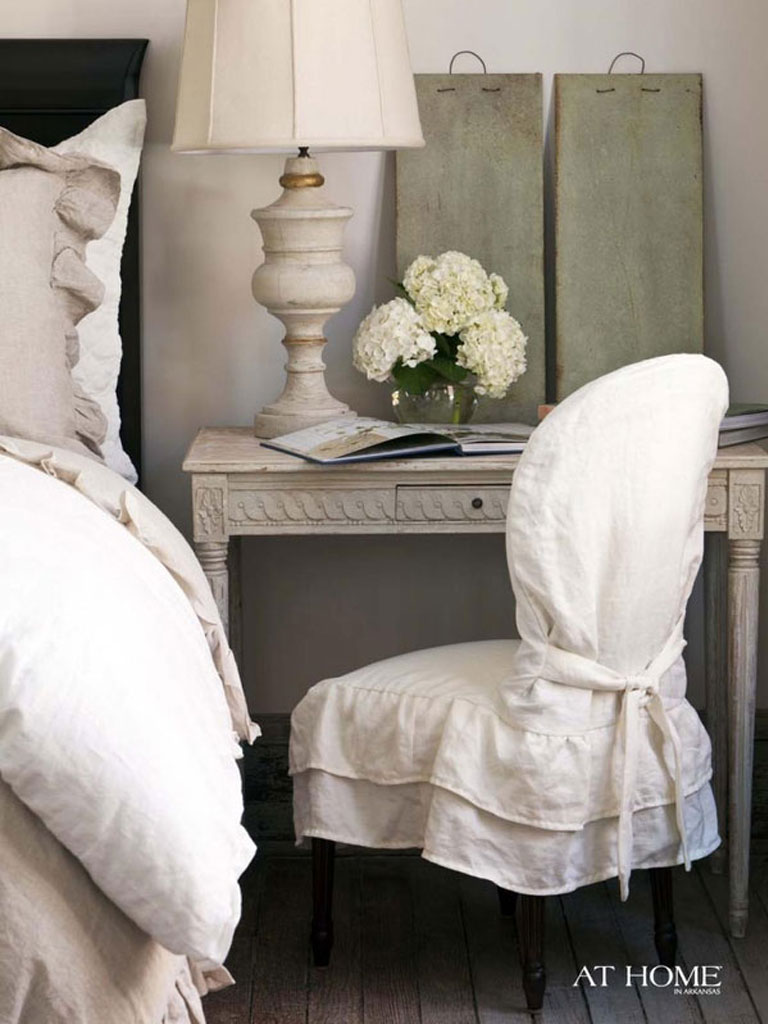 Linen slipcovered chair in bedroom.