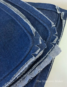 Blue denim piping stitched to cushion covers.