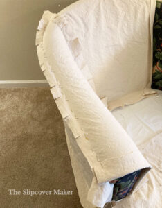Natural canvas chair slipcover pinned arm.