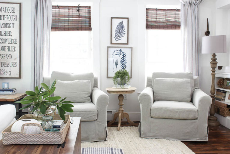 A pair of linen slipcovered chairs in living room.