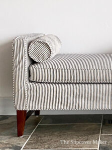 Indigo ticking stripe slipcover for a living room bench seat.