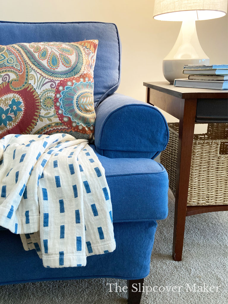 Blue slipcovered sofa with arm covers.