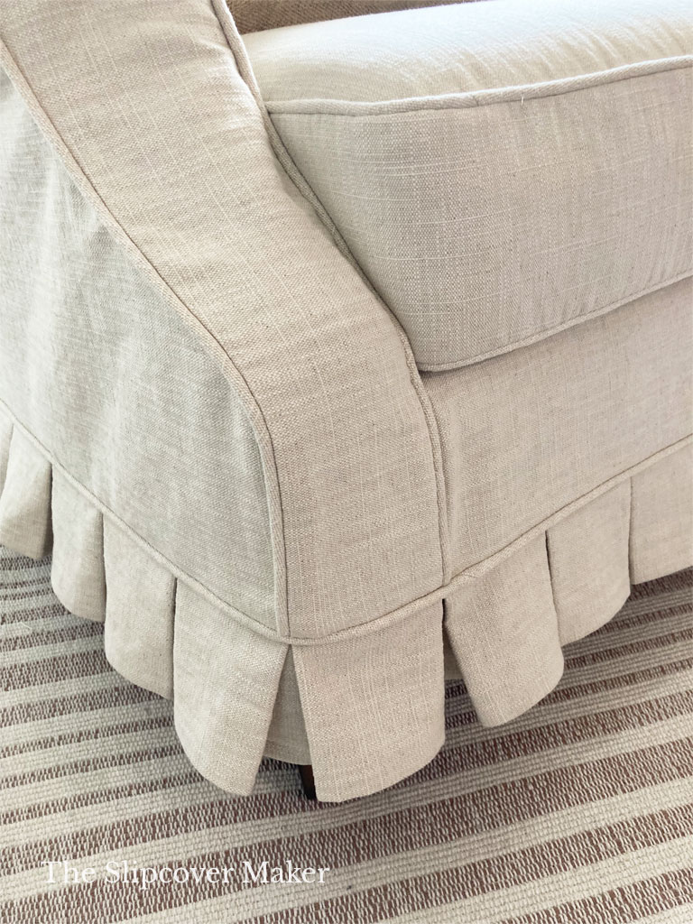 Pleated skirt slipcover in natural cot linen canvas.
