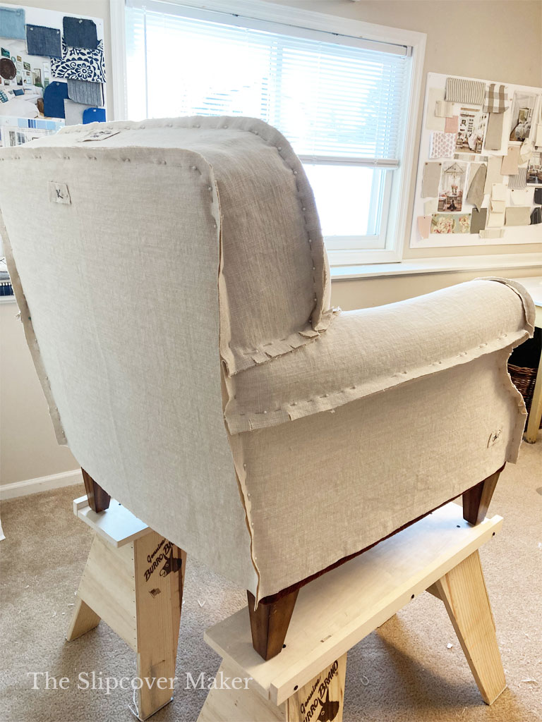 Slipcover pin fitted on armchair sitting on risers.