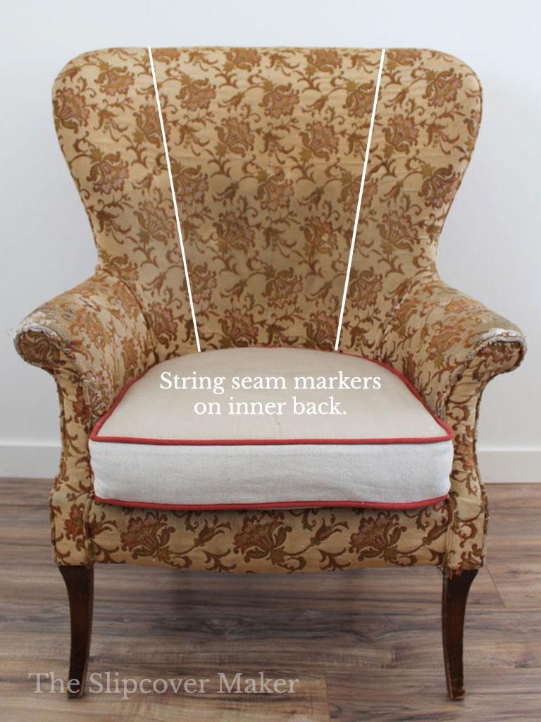 Old wingback chair with string marking the seam.