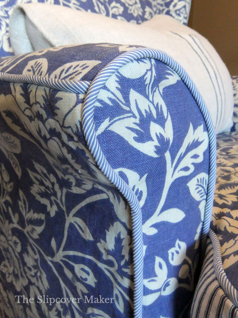 Blue floral chair slipcover with stripe piping.