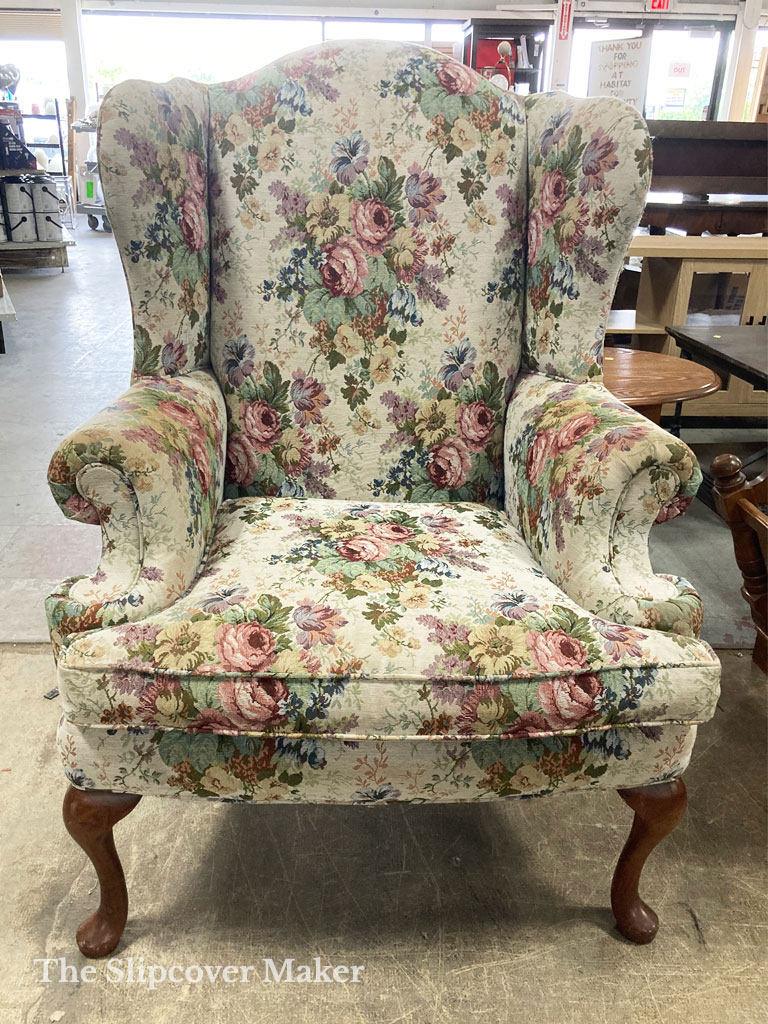 Vintage floral wingback chair with telephone-shaped arms.