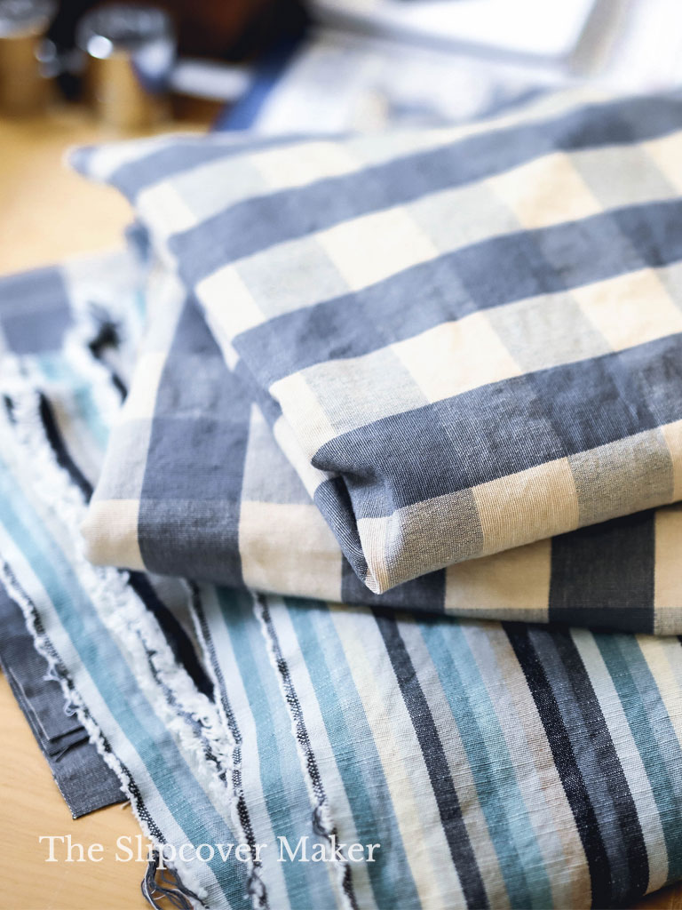 Blue check and stripe slipcover fabrics on table.