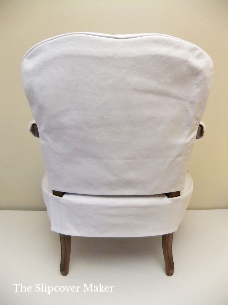 Two piece white slipcover on French chair.