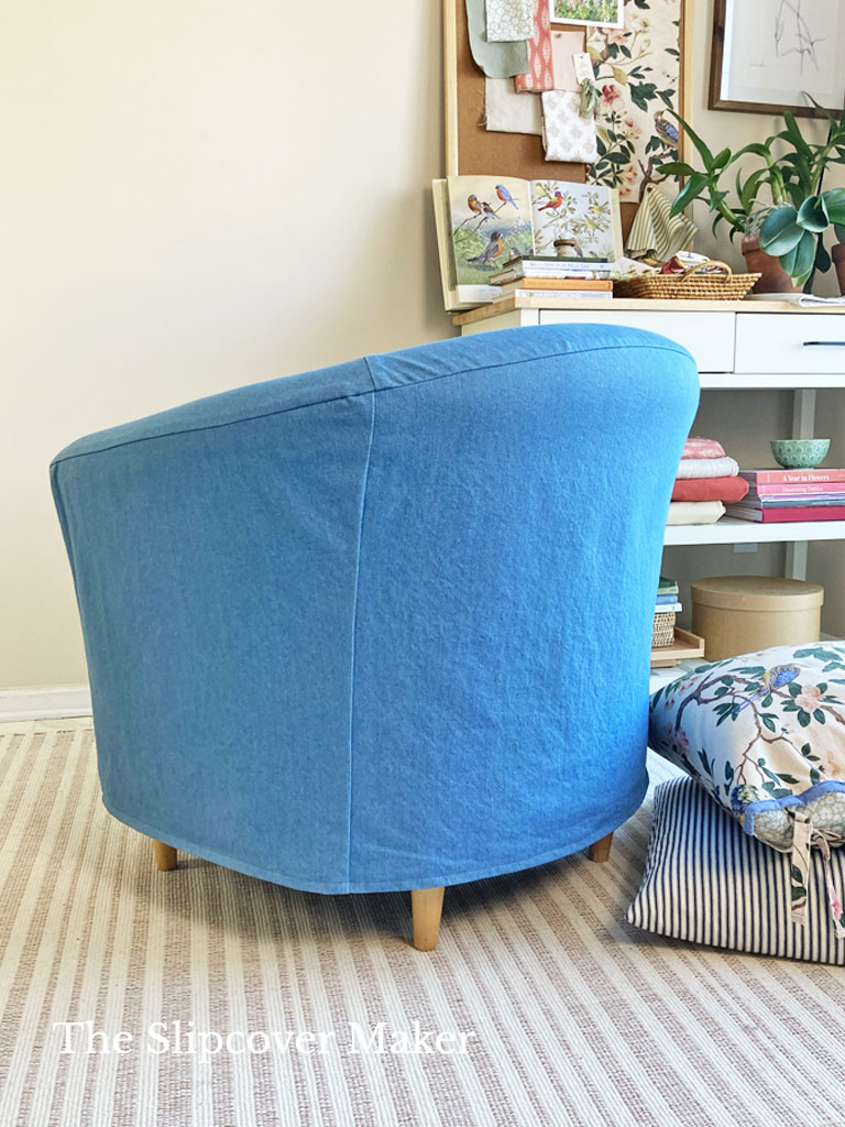 Blue denim slipcover on barrel back chair, back view.
