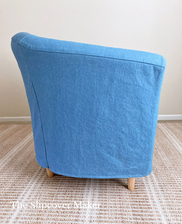 Side view of blue denim slipcover on barrel back chair.