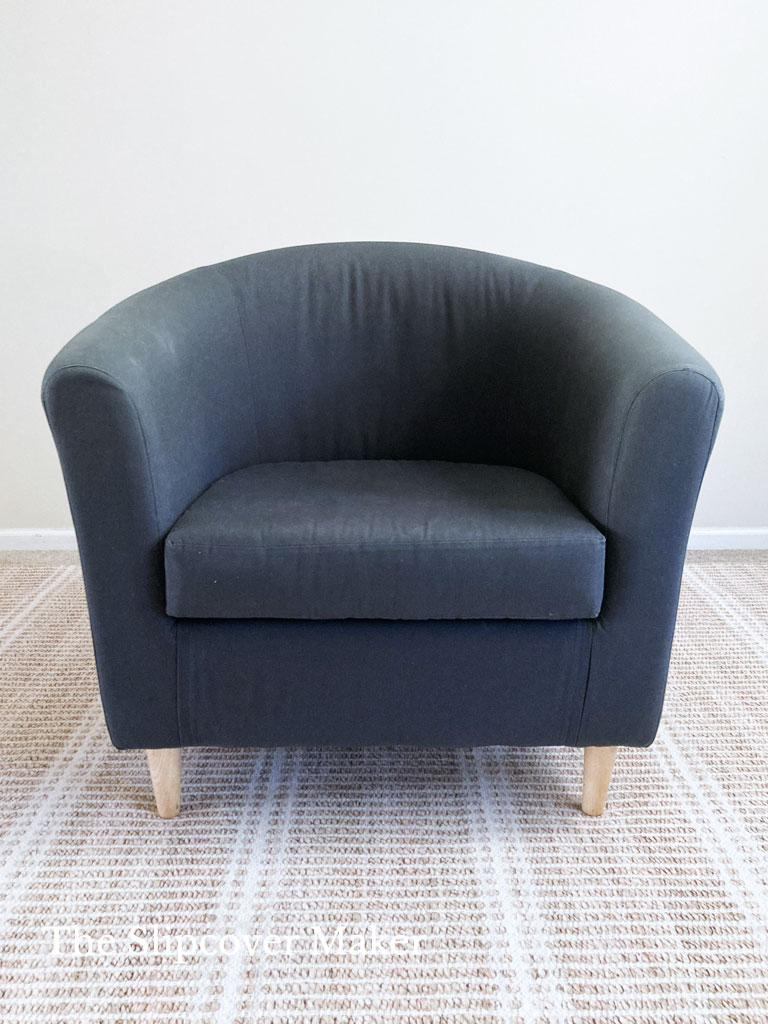 Black upholstered barrel back chair front.