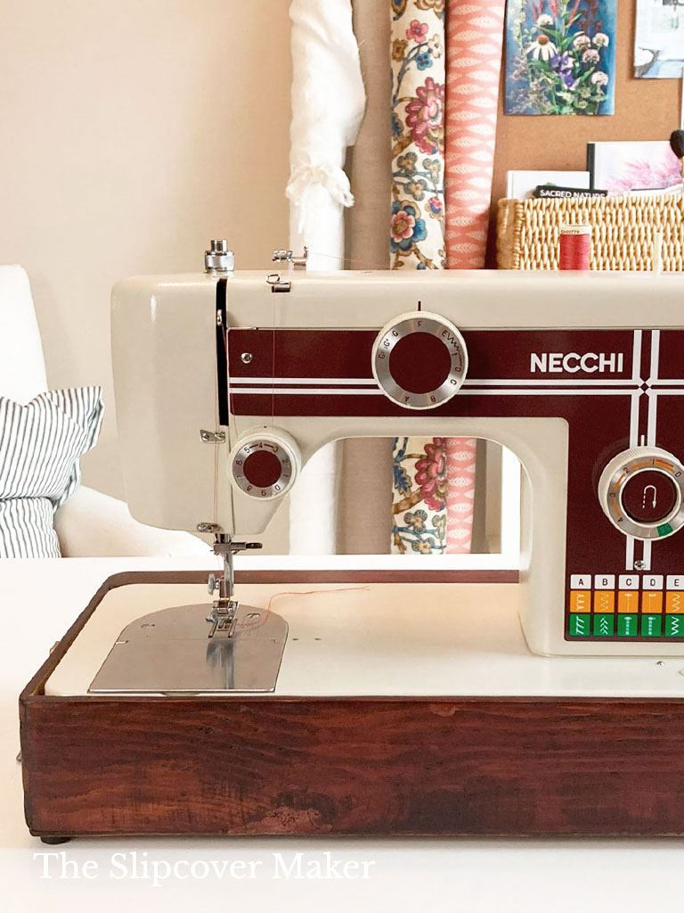 Vintage Necchi sewng machine on table.