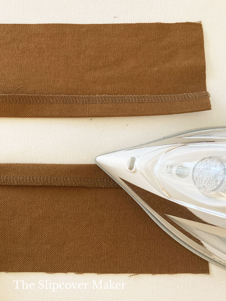 Turn and press brown canvas zipper panel edges.