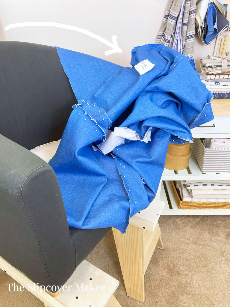 Removing slipcover from the left arm.
